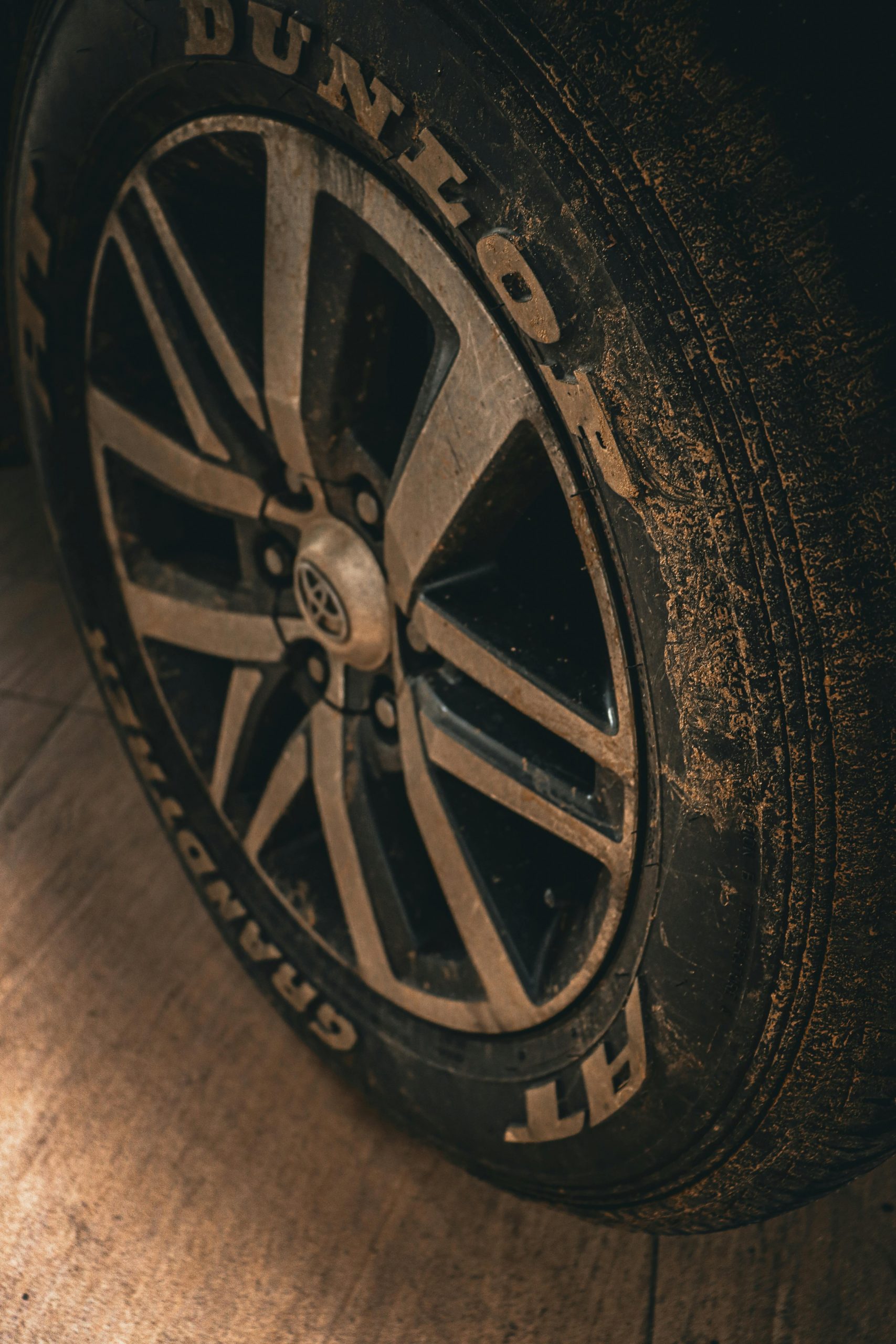 A detailed close-up of a dirty car tire on a Toyota vehicle.